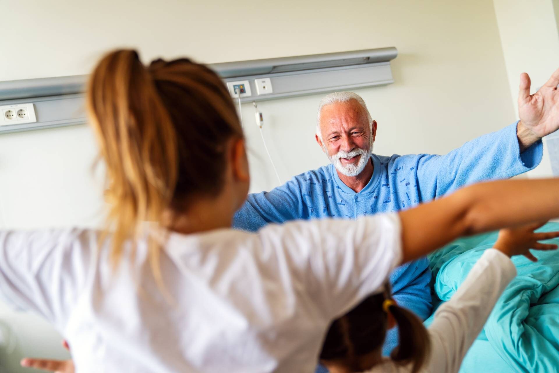 Happy senior man is recovering from the coronavirus is visited by his grandchildren