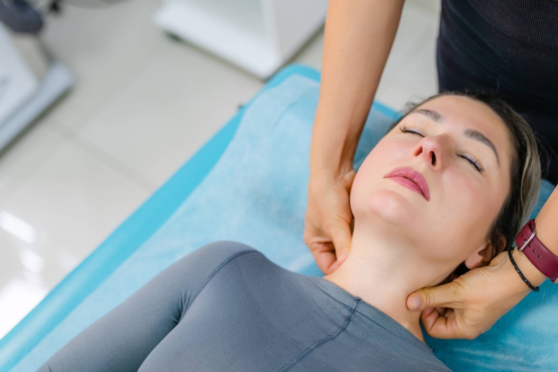 Close-up hands of an unidentified young woman masseur doing facial massage to beautiful young caucasian client woman at spa salon. Concept of therapeutic anti-aging skin